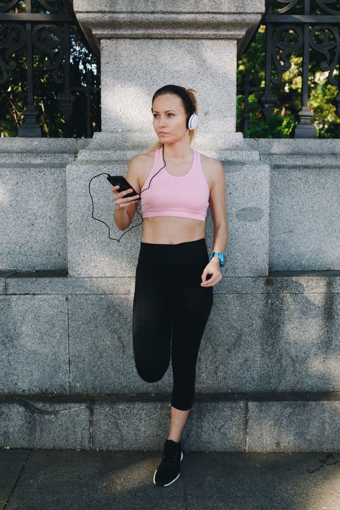 Woman with sportswear listening to music with headphones