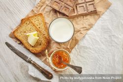Buttered toast with milk, chocolate, knife and jam on craft paper 5oAeQb