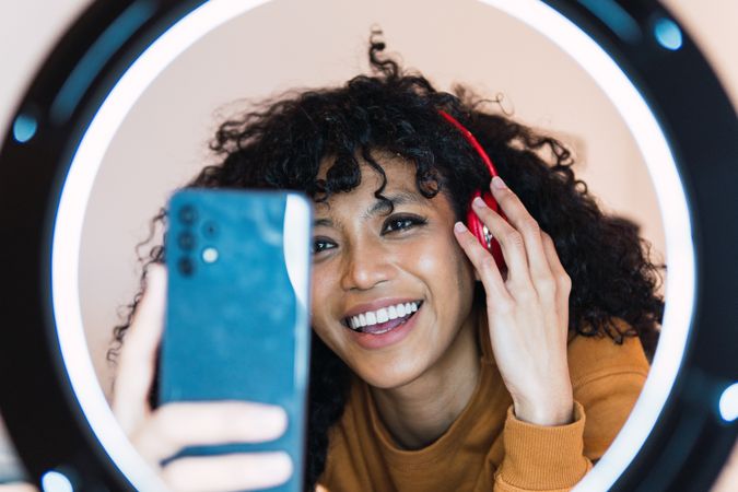 Happy Black woman taking selfie on smartphone