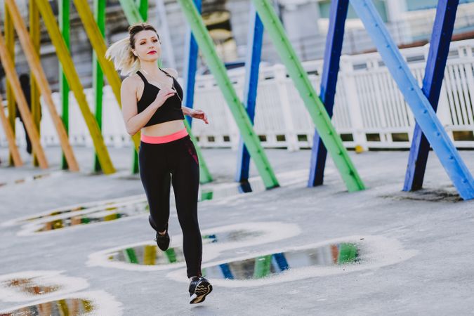 Woman with earphones running on street