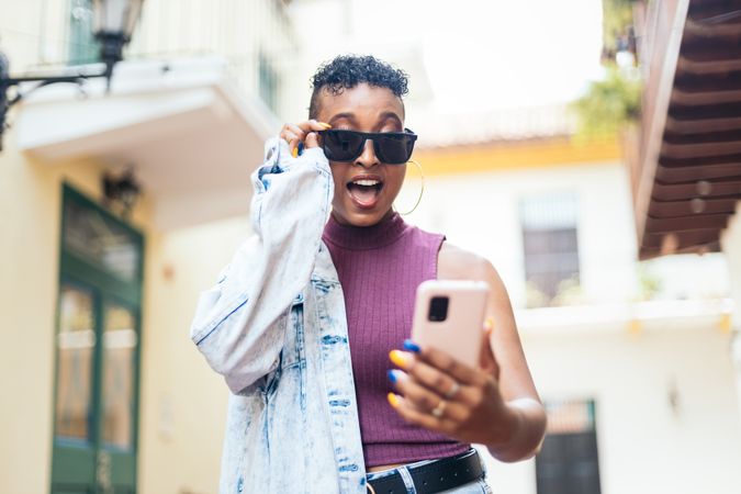 Cool Latin American woman using smartphone in the city