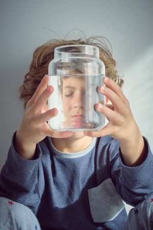 Sad boy with glass bottle of water