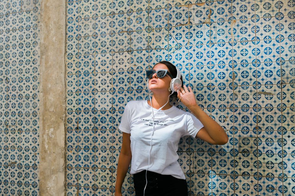 Cheerful casual woman in sunglasses standing on city street