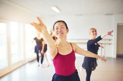 Women with arms outstretched at ballet class