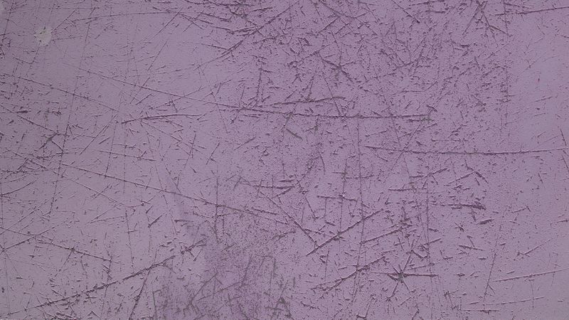 Purple concrete wall with rough scratched texture and grunge surface detail