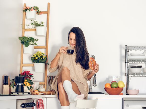Delighted woman enjoying coffee at home