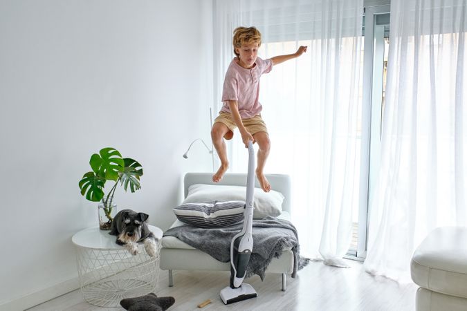 Boy jumping and cleaning floor