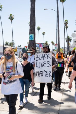 Los Angeles, CA, USA — June 14th, 2020: protestors walking down street carrying signs at BLM march