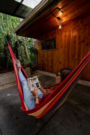 Woman lying on hammock and reading a book outdoor