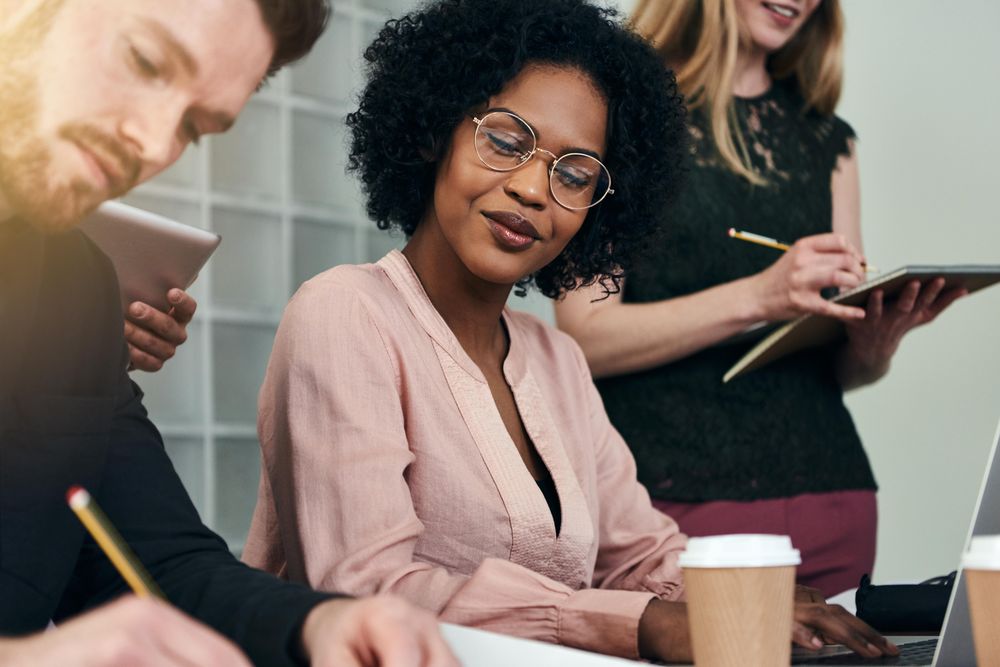 Woman observing her colleagues writing