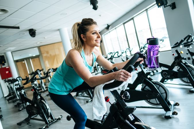 Woman with towel and water on exercise machine