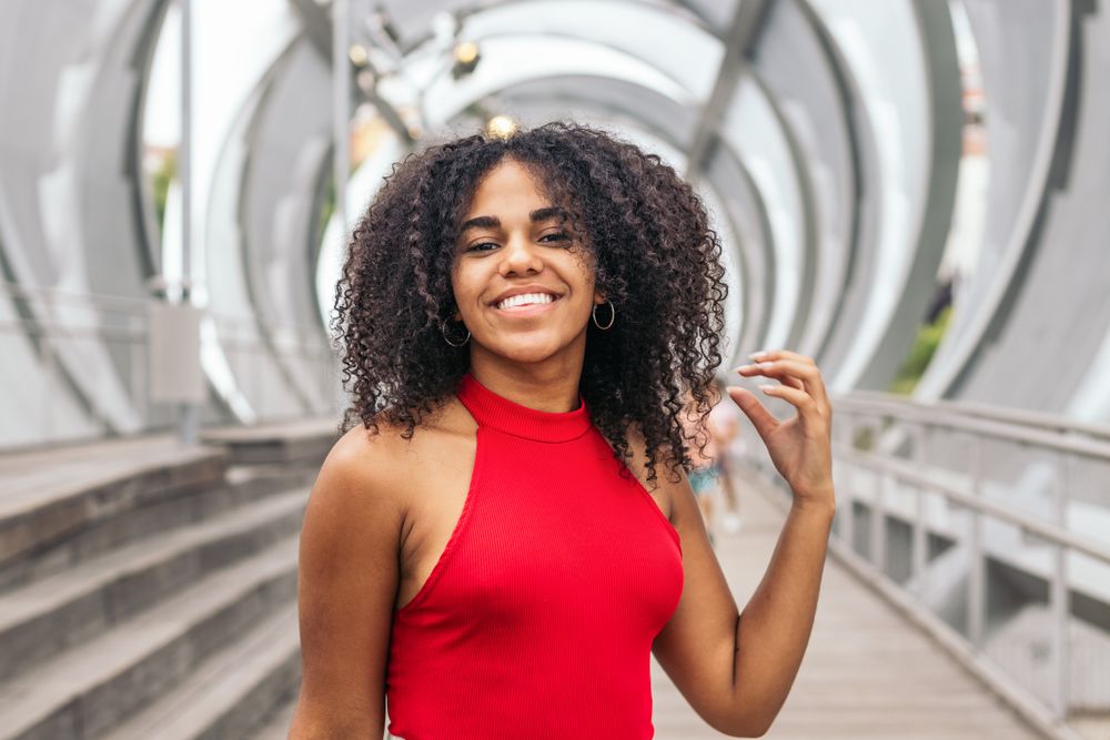 Portrait of a woman with afro hair enjoying in summer in the city