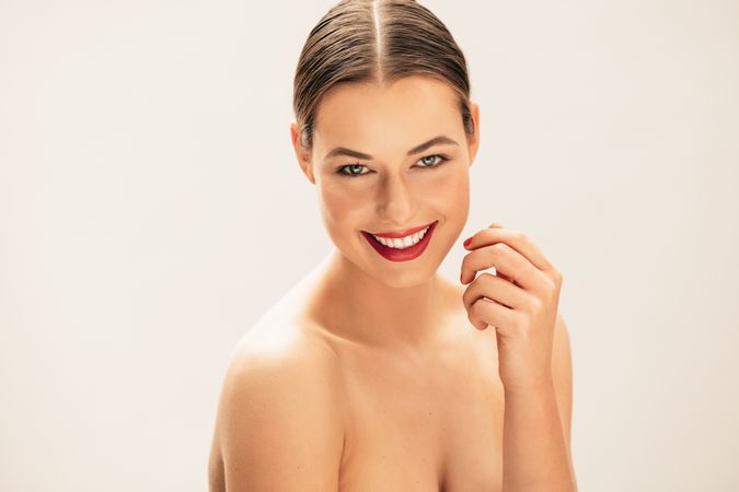 Portrait of beautiful young topless woman smiling in studio