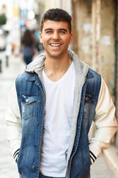 Happy man in jean jacket walking on street