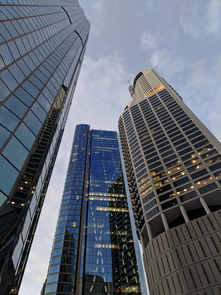 Bottom view of three high rise glass buildings