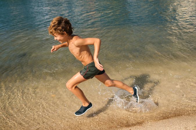 Tanned kid having fun on beach