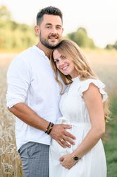 Happy expectant couple hugging in countryside