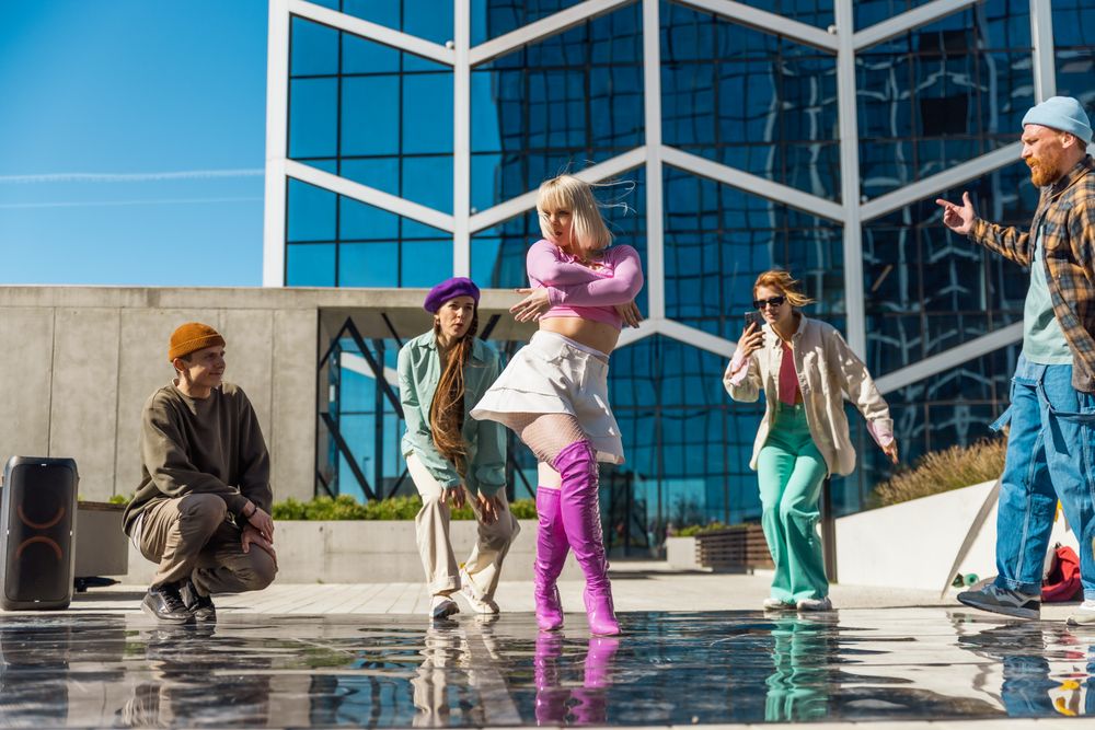 Outdoor Scene Of Young Adults Engaging In A Dynamic Dance Session Against A Modern Architectural Background