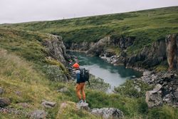 Man hiking along green mountains