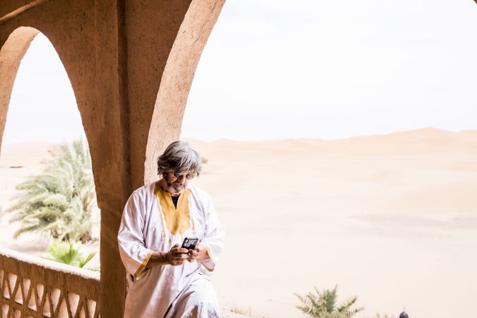 Man using phone in balcony near desert