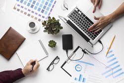Arrangement of office elements with two people on light desk