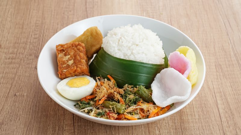Nasi Gudangan, rice served with various vegetable with grated coconut seasoned and various side dishes. Indonesian food