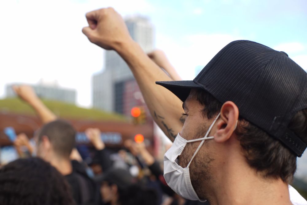 Protestor with facemasks raising their fists up at a Black Lives Matter protest