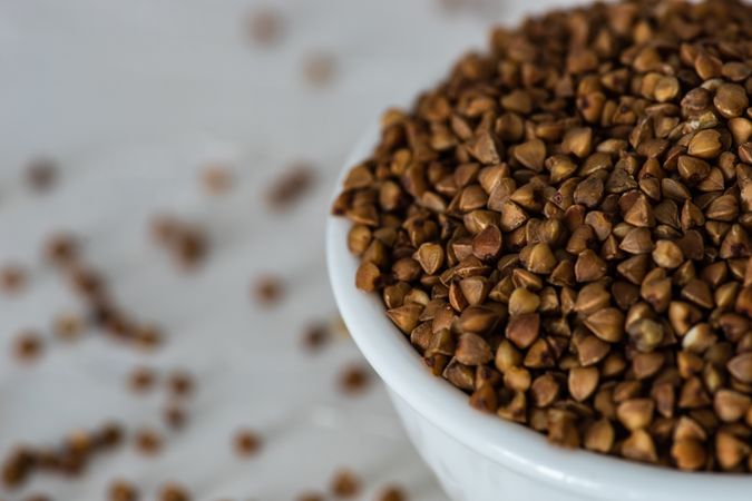 Close up of organic raw buckwheat seeds in a bowl on wooden table 
