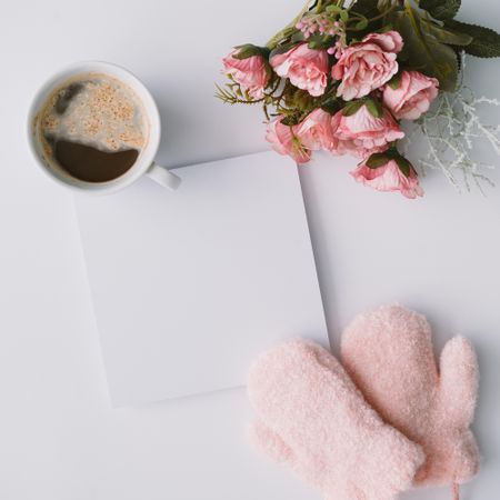Coffee, mittens and paper card with flowers