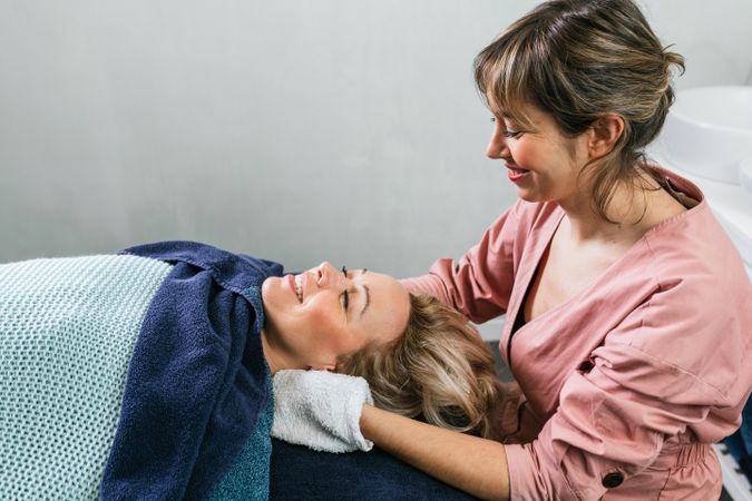 Cosmetologist doing skin care treatment on face of woman in beauty salon