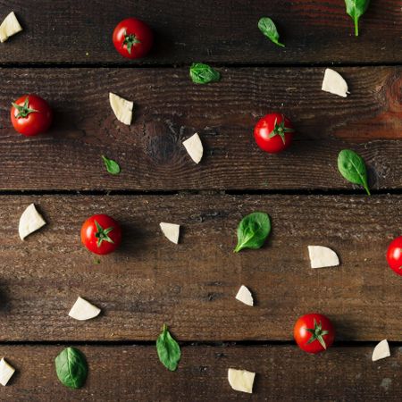 Basil, tomatoes, and cheese on wooden background