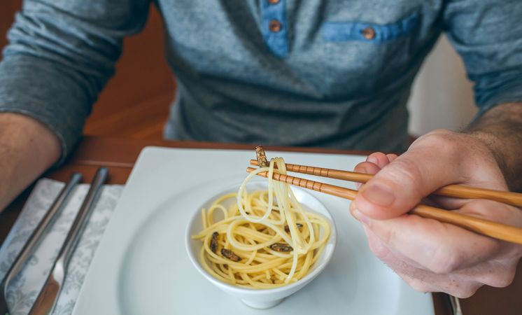 Man eating spaghetti and crickets