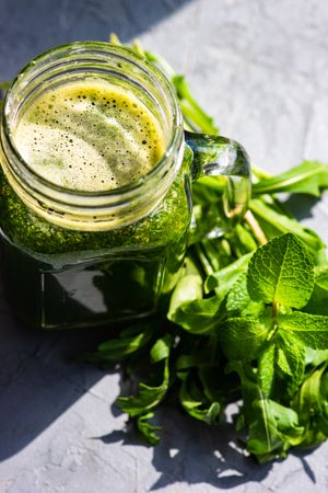 Sunny counter with green smoothie and herbs