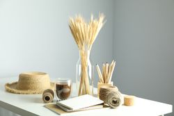 Work table with yarn, notebooks, pencils, dried flowers, with hat