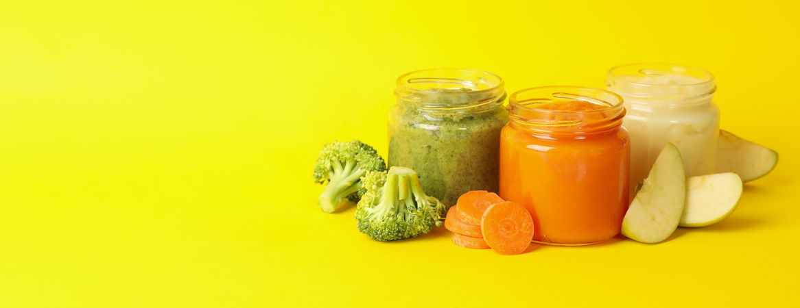 Composition with vegetable puree on yellow background. Baby food