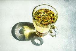 Freshly poured herbal tea in glass mug