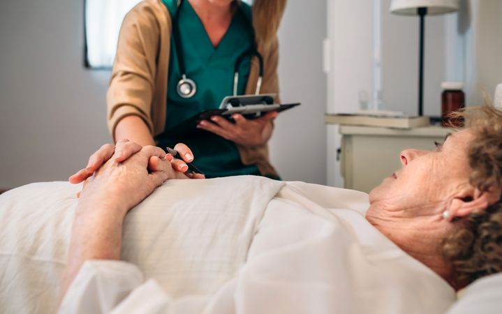 Female doctor comforting older patient