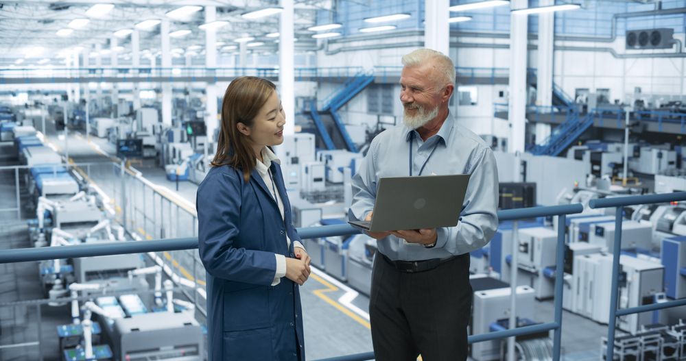 Experienced Mature Engineer Giving an Electronics Factory Tour to Young Japanese Student. Asian Female with Technical Background Asking Questions About Production, Manufacturing, Research