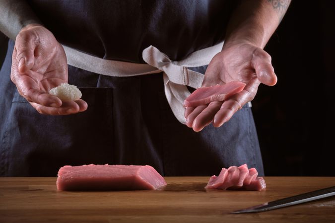 Male shushi man hands preparing different pieces of makis