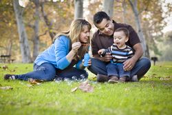 Happy Family Playing with Bubbles In Park