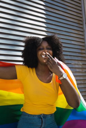 Woman posing happily with the LGBT flag