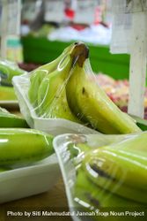 Banana fruits wrapped and for sale in grocery store 4d87lL