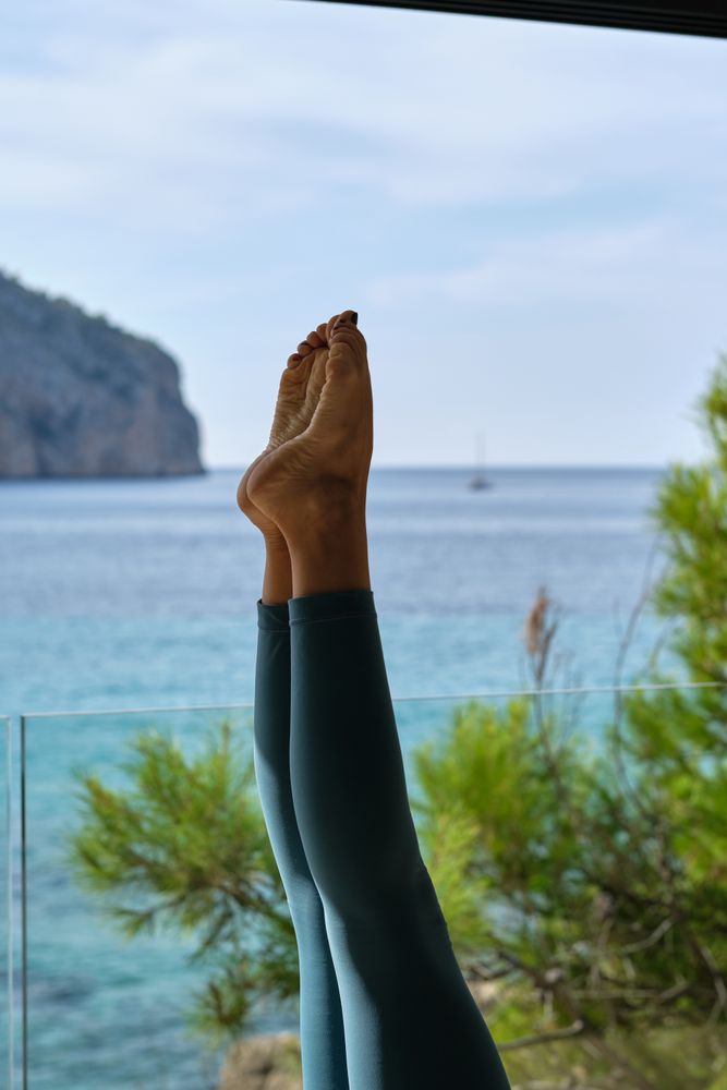 Crop woman doing yoga in headstand pose
