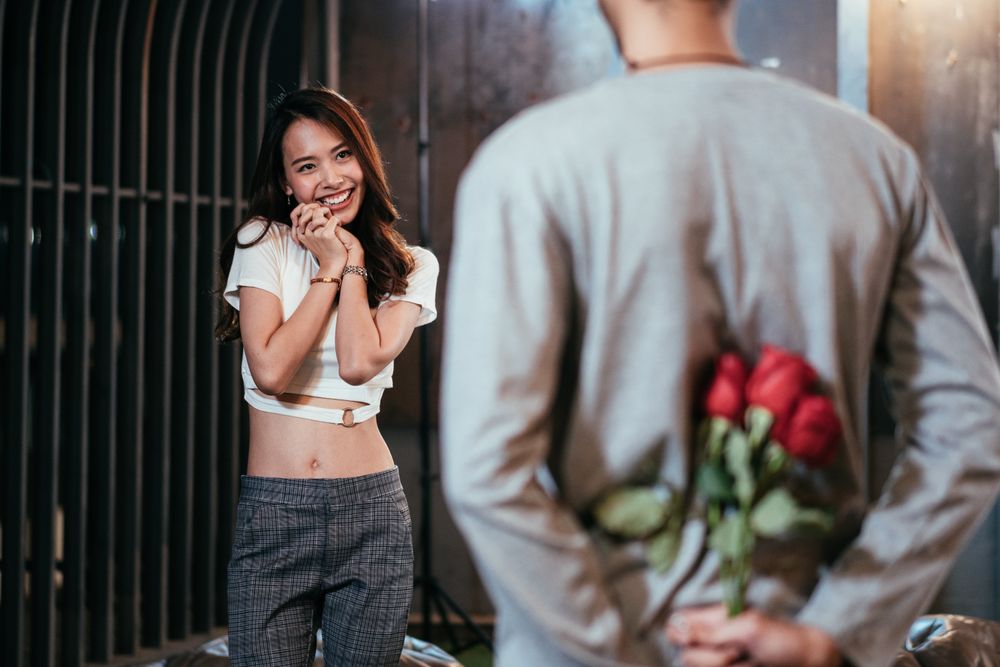 Man hiding red roses to surprise his girlfriend on Valentine's day