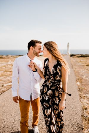 Happy lovers walking on path from sea