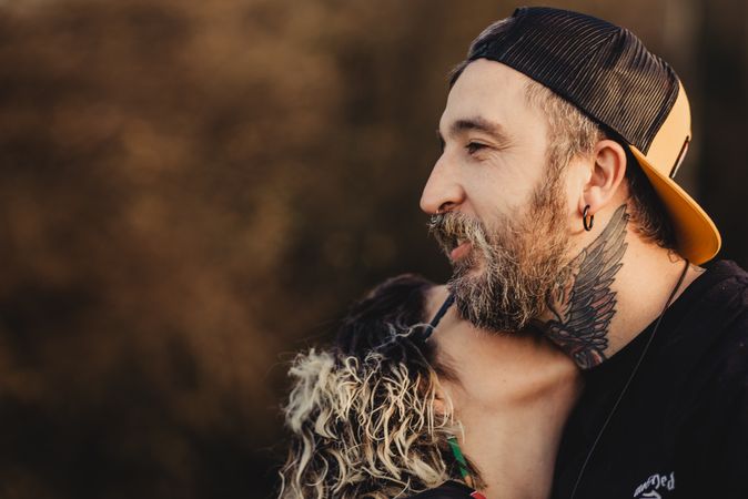 Happy couple hugging near tree in park