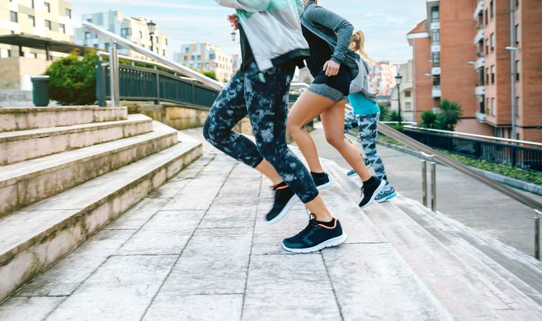 Side view of women training running up stairs in town