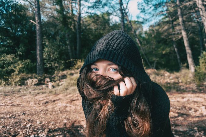Woman with blue eyes covering her mouth with her hair