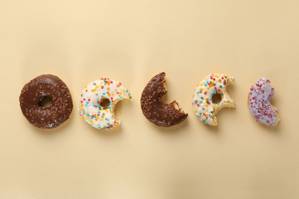 Tasty donuts on beige background, space for text