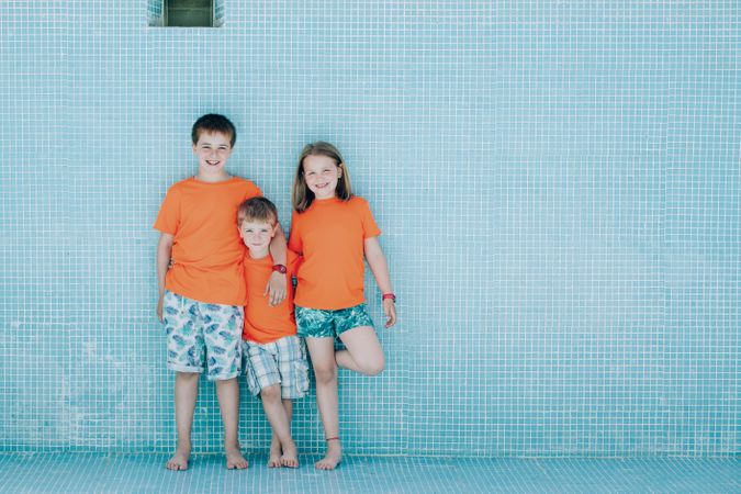 Children standing in empty pool and looking at camera